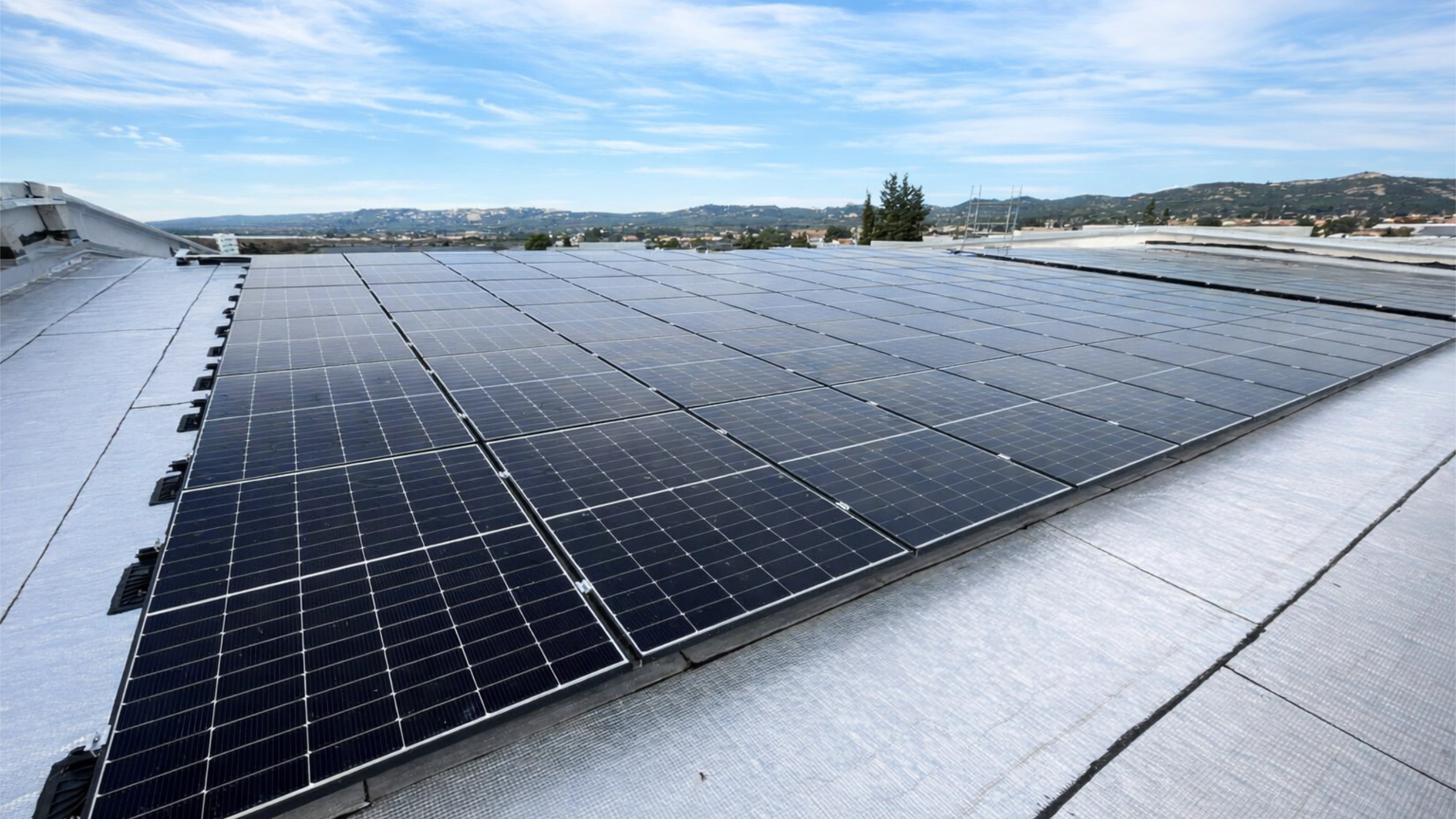 Installation professionnelle de photovoltaïque de 150 kWc sur toiture plate pour un site industriel à La Fare les Oliviers, réalisée pour un fabricant de piscines.