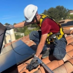 Technicien Sérénit'Aix fixant les rails d'un panneau solaire sur une toiture de maison individuelle aux Pennes Mirabeau