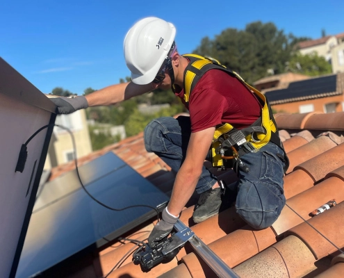 Technicien Sérénit'Aix fixant les rails d'un panneau solaire sur une toiture de maison individuelle aux Pennes Mirabeau