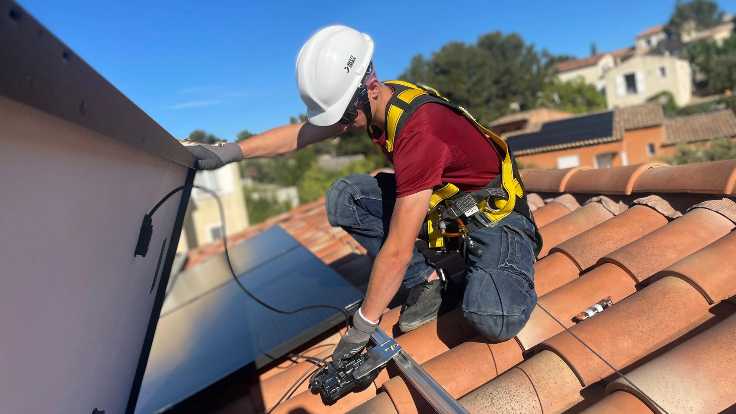 Technicien Sérénit'Aix fixant les rails d'un panneau solaire sur une toiture de maison individuelle aux Pennes Mirabeau
